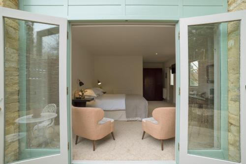 a bedroom with a bed and a table and chairs at Old Swan & Minster Mill in Minster Lovell