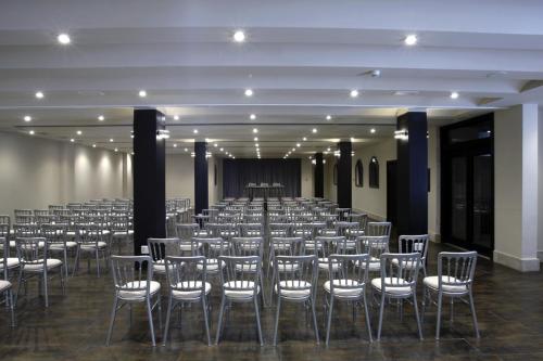 a large room with rows of chairs and a stage at Hotel Palacio de Mengibar in Mengibar