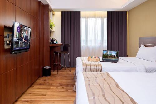 ein Hotelzimmer mit 2 Betten und einem Flachbild-TV in der Unterkunft Da Vienna Boutique Hotel in Nagoya