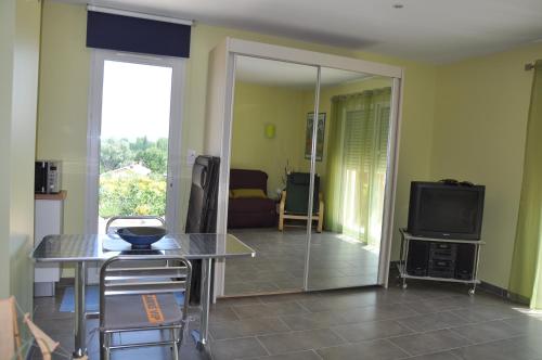 un salon avec une table et une télévision dans l'établissement Martichris, à Châteauneuf-de-Gadagne