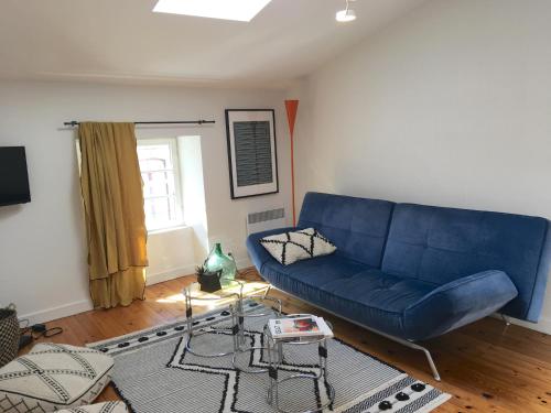 un salon avec un canapé bleu et une fenêtre dans l'établissement Hotel de Ville 3 et Parking, à La Rochelle