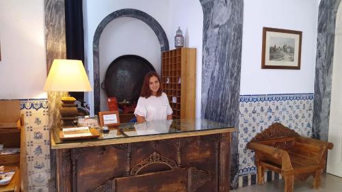 a woman standing at a counter in a room at Hotel de Moura in Moura