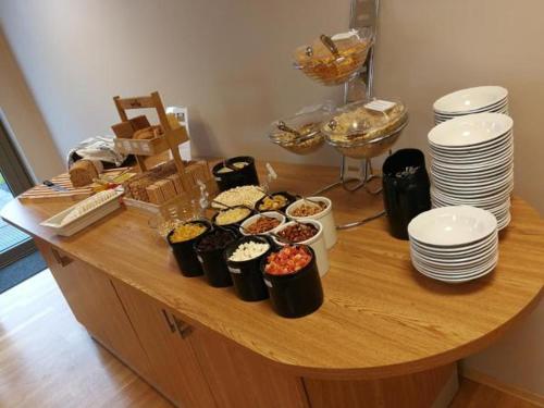 una mesa con un montón de comida y platos en ella en Dombåstun en Dombås
