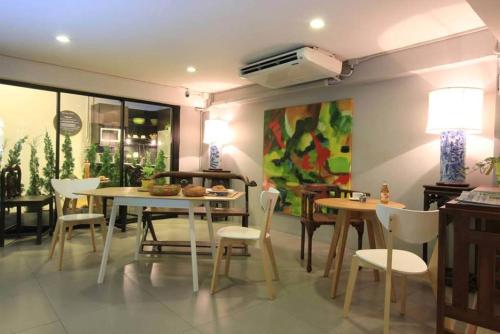 a dining room with tables and chairs and a fan at S1hostel Bangkok in Bangkok