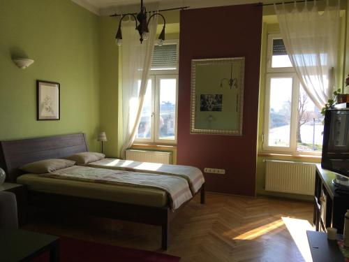a bedroom with a bed and two windows at Studio along the Danube in Budapest