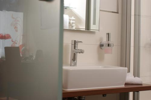 a bathroom with a sink and a mirror at Hotel Peterhof - urban lifestyle Kempten in Kempten