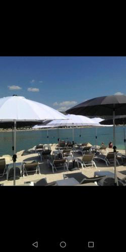 a group of chairs and umbrellas on a beach at Tomena apartments in Trogir