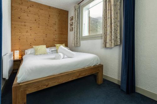 1 dormitorio con 1 cama blanca y ventana en Apartment Internationale en Chamonix-Mont-Blanc