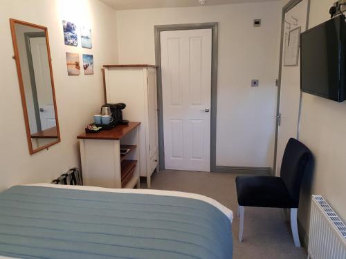 a room with a bed and a desk and a mirror at Compston House B & B in Ambleside