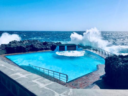 een groot zwembad met golven in de oceaan bij Studio 1 Hab in Pájara