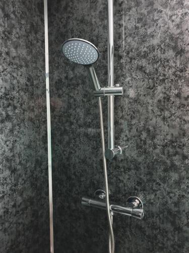 a shower with a shower head and a shower head at Compston House B & B in Ambleside