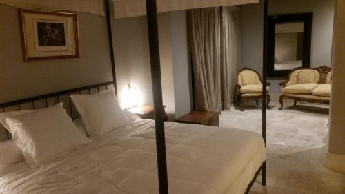 a bedroom with a large white bed in a room at Hotel Palacio de Mengibar in Mengibar