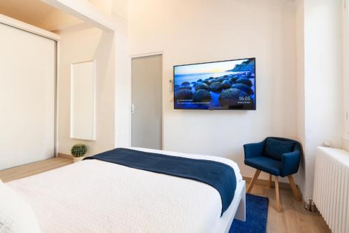 une chambre avec un lit blanc et une chaise bleue dans l'établissement Arles Holiday - La Terrasse, à Arles