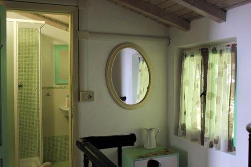a bathroom with a mirror on the wall and a chair at Fattoria Cristina - Bilo Verde in Castelnuovo Magra