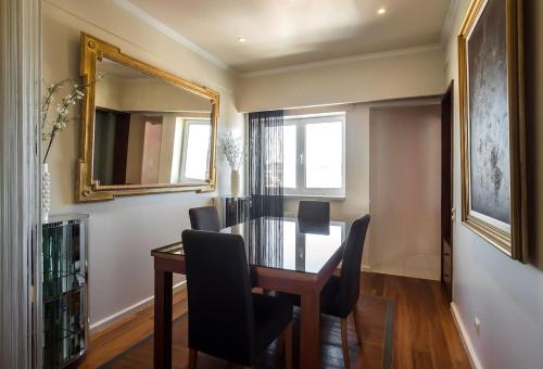a dining room with a table and chairs and a mirror at Azores 19th Floor (180º ocean & city view) in Ponta Delgada