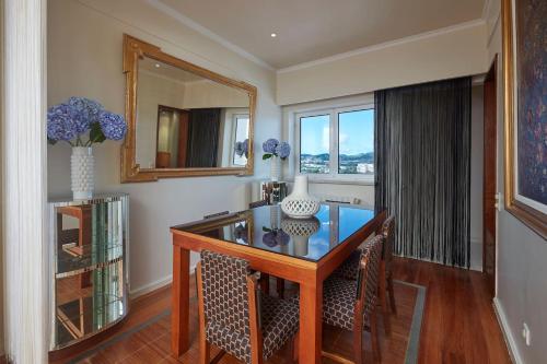a dining room table with chairs and a mirror at Azores 19th Floor (180º ocean & city view) in Ponta Delgada