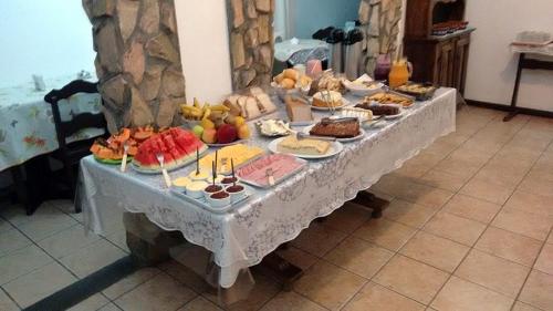 uma mesa cheia de diferentes tipos de alimentos em em Schulz Pousada em Joinville