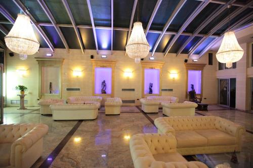 a large room with couches and chandeliers at Hotel Astoria in Igoumenitsa