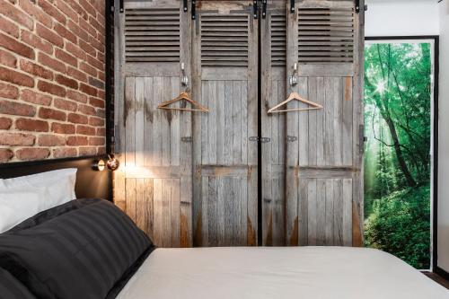 - une chambre avec une porte en bois et un lit dans l'établissement Suite Vintage Rouen, à Rouen