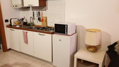 a kitchen with a microwave sitting on top of a refrigerator at Casa Barca in Verona