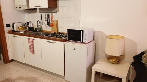 cocina con microondas sobre una nevera en Casa Barca, en Verona