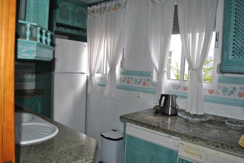 una pequeña cocina con fregadero y ventana en Apartamento Rural Prado del Rey en Prado del Rey