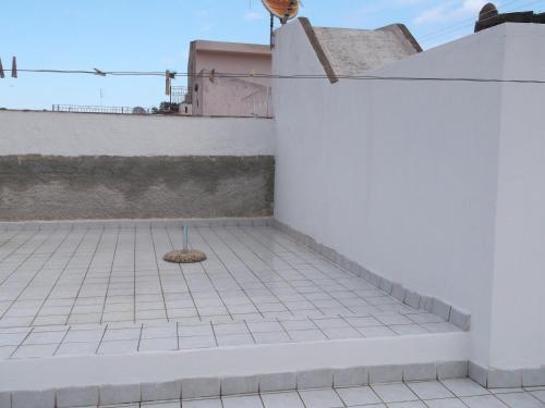 a white wall with a drain on a tile floor at centrostoricolipari in Lipari