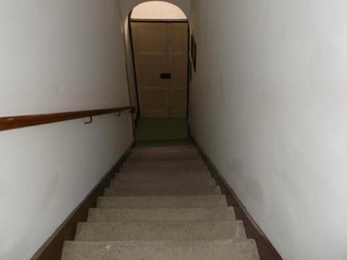 a hallway with stairs leading to a door with a window at centrostoricolipari in Lipari