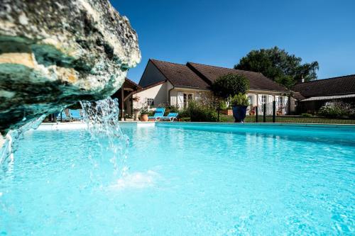 a swimming pool with a water fountain at Le Clos Lamy in Mont-près-Chambord