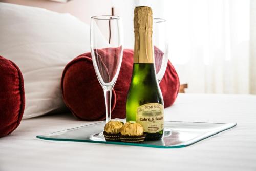 Una botella de champán y dos copas en una mesa. en Hotel Costasol en Almería