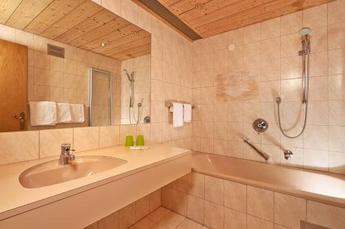 a bathroom with a sink and a tub and a shower at Hotel Alt Vent Tyrol in Vent