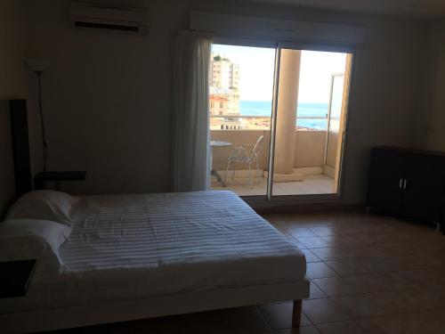 Schlafzimmer mit einem Bett und Blick auf einen Balkon in der Unterkunft Studio with the sea view, balcony, Monaco, Riviera, Jardin's d'Elisa in Beausoleil