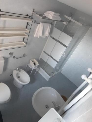 a bathroom with a white toilet and a sink at Il Grifo Camere e Suites in Grosseto