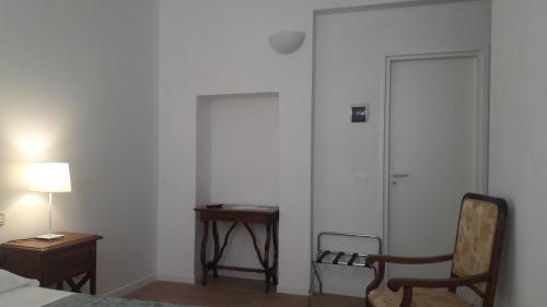 a bedroom with a bed and a chair and a table at Il Grifo Camere e Suites in Grosseto