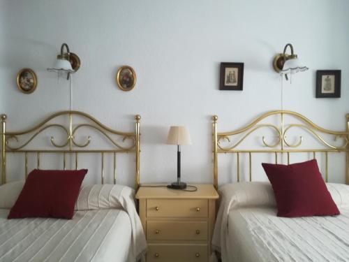 1 dormitorio con 2 camas con almohadas rojas y mesa en Casamami, en Nájera