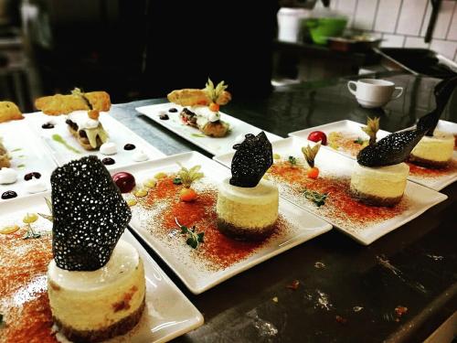 a bunch of desserts on plates on a table at Hotel Tókert Szálloda és Étterem in Lillafüred