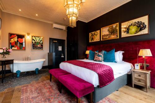 a bedroom with a bed and a bath tub and a bed sidx sidx sidx sidx at The Park Hotel in Teddington