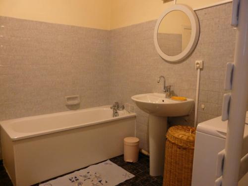 ein Badezimmer mit einer Badewanne, einem Waschbecken und einem Spiegel in der Unterkunft T4 de 85m2 avec garage en plein coeur de Sète in Sète