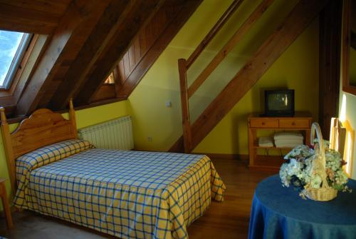 a bedroom with a bed and a table with a tv at Casa Es Neres in Les