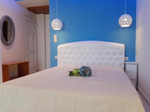 Un dormitorio con una cama blanca con flores. en Xenios Zeus, en Nea Iraklitsa