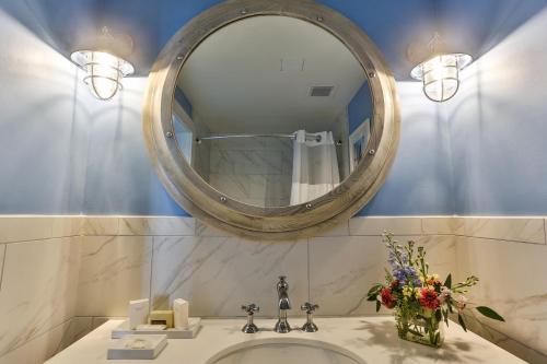 a bathroom with a sink with a large mirror at Harborside at Charleston Harbor Resort and Marina in Charleston