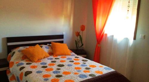 テーラス・デ・ボウロにあるCasa da Motaのベッドルーム1室(オレンジ色の枕と窓付)