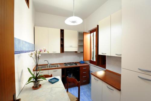 una cucina con armadi bianchi e un tavolo con una pianta di Amalfi Blue FLowers B ad Amalfi