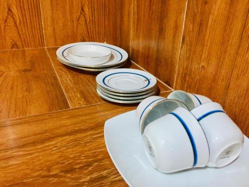 two stacks of plates sitting on a table with a white plate at Sweet Home Tourist Rest, Cooking Classes & Tours in Anuradhapura
