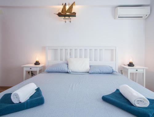 a bedroom with a large bed with two towels on it at Villa Lapis Vis in Rukavac