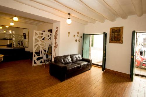 a living room with a leather couch in a room at Cusco Plaza Nazarenas in Cusco