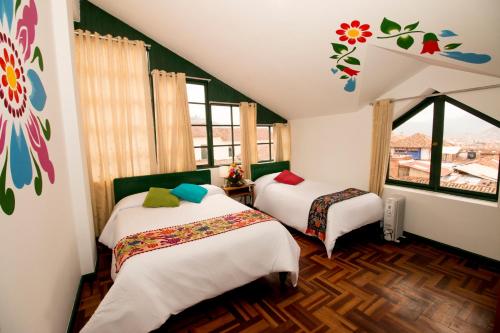 a bedroom with two beds and a window at Cusco Plaza Nazarenas in Cusco