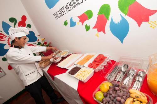 a chef standing next to a table with food at Cusco Plaza Nazarenas in Cusco