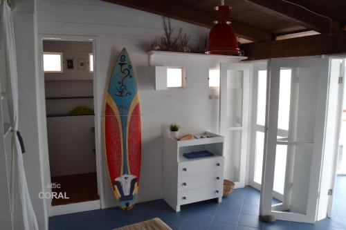 a surfboard leaning against a wall in a room at BookingBoavista - Coral in Sal Rei