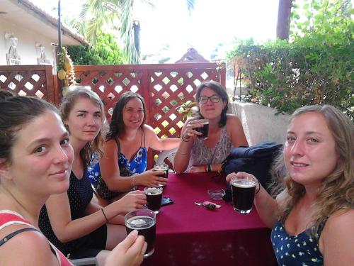 a group of women sitting at a table drinking beer at Hostel Julieta in Rivas
